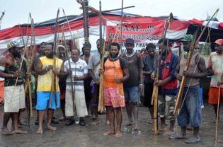 Papuan Amungme tribesmen armed with traditional bows and arrows stand guard before the strikers