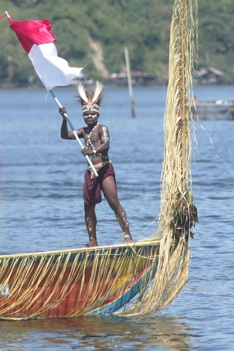 Love for the country: A man in a traditional outfit waves a red and white flag during the opening of Lake Sentani Festival, Papua, on June 19.