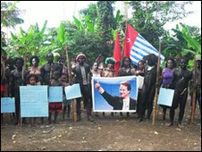 Tribespeople hold up a poster of David Cameron