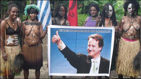 Tribespeople hold up a poster of David Cameron. Photo: Albert 
Tabuni